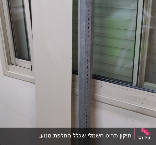 תריסים סגורים עם לוח מתכת ועמוד ליד חלון
